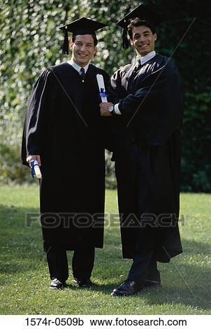 Portrait of two young men wearing graduation outfits holding diplomas View Large Photo Image Stock Image - Portrait of two young men wearing graduation outfits holding diplomas. Fotosearch