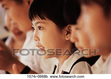 Stock Image - Side profile of a girl in class. Fotosearch