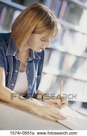 Side profile of a woman writing in a notebook with a pencil View Large Photo Image Stock Image - Side profile of a woman writing in a notebook with a pencil. Fotosearch