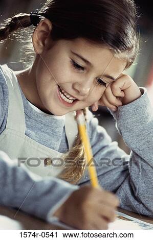 Smiling girl writing with a pencil View Large Photo Image Stock Image - Smiling girl writing with a pencil. Fotosearch
