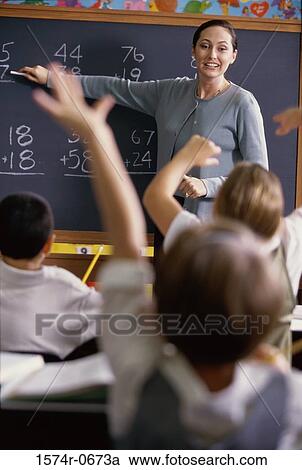 Teacher pointing to a chalkboard in class View Large Photo Image Stock Image - Teacher pointing to a chalkboard in class. Fotosearch