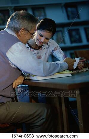 Teenage girl and a man studying together View Large Photo Image Stock Photo - Teenage girl and a man studying together. Fotosearch