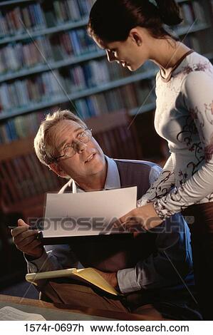 Teenage girl giving a man a document View Large Photo Image Stock Image - Teenage girl giving a man a document. Fotosearch
