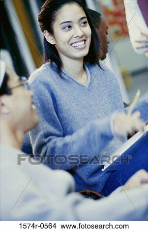Teenage girl smiling in class View Large Photo Image Picture - Teenage girl smiling in class. Fotosearch