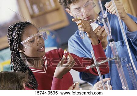 Stock Photography - Teenagers conducting an experiment in a chemistry laboratory. Fotosearch