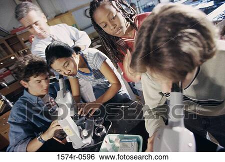 Stock Photograph - Teenagers looking through microscopes. Fotosearch