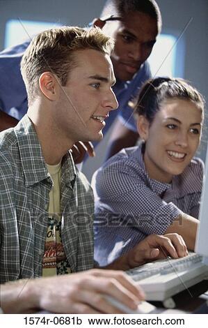 Stock Image - Two young men and a young woman studying together. Fotosearch