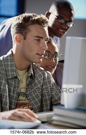 Two young men and a young woman studying together View Large Photo Image Stock Image - Two young men and a young woman studying together. Fotosearch
