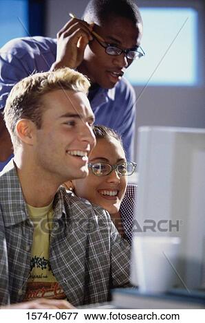 Stock Photo - Two young men and a young woman studying together. Fotosearch