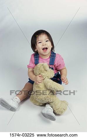 Baby girl playing with a teddy bear View Large Photo Image Stock Photography - Baby girl playing with a teddy bear. Fotosearch