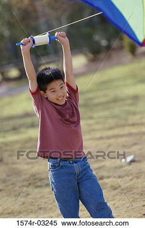 Stock Photography - Boy flying a kite. Fotosearch