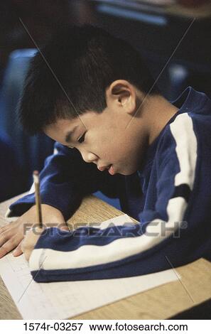 Boy writing on a paper with a pencil View Large Photo Image Stock Photo - Boy writing on a paper with a pencil. Fotosearch