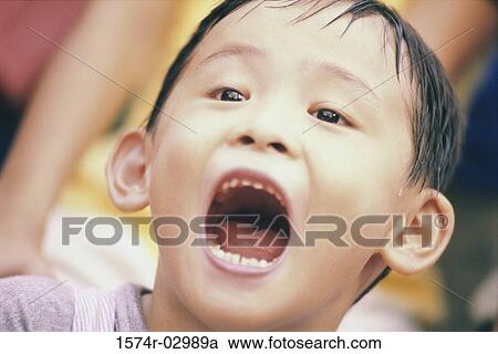 Stock Image - Close-up of a boy with his mouth open. Fotosearch