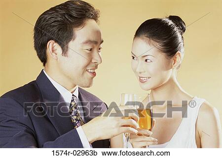 Stock Image - Close-up of a young couple toasting. Fotosearch