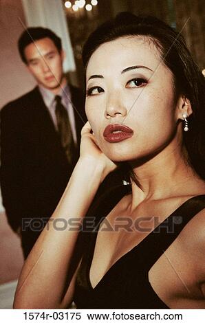 Close-up of a young woman with a young man standing behind her View Large Photo Image Stock Photography - Close-up of a young woman with a young man standing behind her. Fotosearch