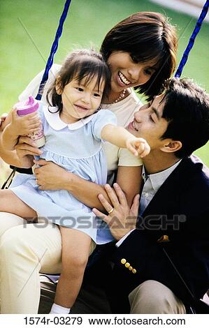 Close-up of parents playing with their daughter on a swing View Large Photo Image Stock Photo - Close-up of parents playing with their daughter on a swing. Fotosearch