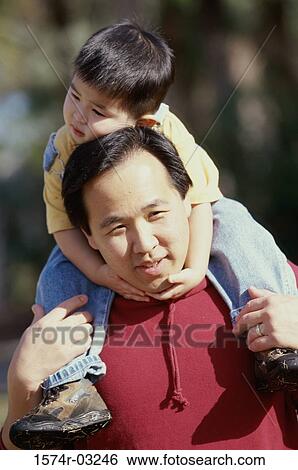 Father carrying his son on his shoulders View Large Photo Image Stock Photograph - Father carrying his son on his shoulders. Fotosearch