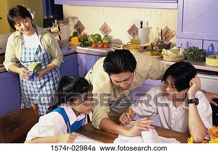 Stock Image - Father helping his son and daughter with their homework. Fotosearch