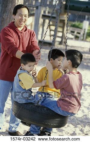 Father playing with his three sons on a swing View Large Photo Image Stock Image - Father playing with his three sons on a swing. Fotosearch