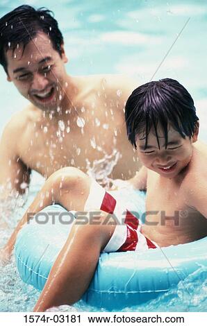 Father with his son playing in a swimming pool View Large Photo Image Stock Image - Father with his son playing in a swimming pool. Fotosearch