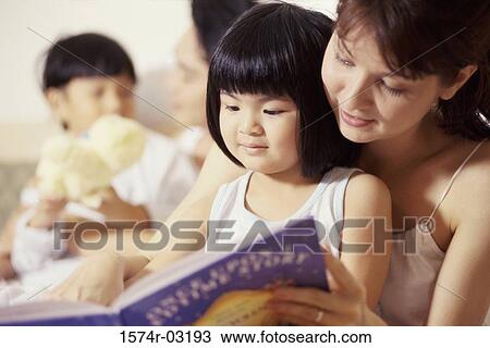 Mother reading a storybook with her daughter View Large Photo Image Stock Image - Mother reading a storybook with her daughter. Fotosearch
