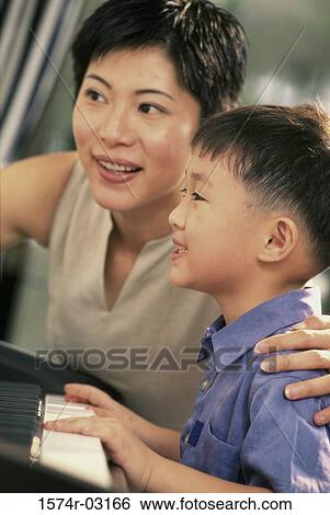 Mother teaching her son how to play the piano View Large Photo Image Stock Photograph - Mother teaching her son how to play the piano. Fotosearch
