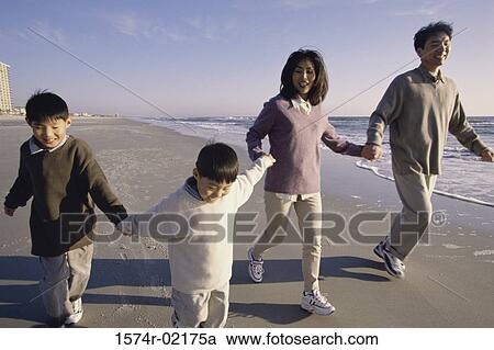 Parents and their two sons holding hands walking on the beach View Large Photo Image Stock Image - Parents and their two sons holding hands walking on the beach. Fotosearch