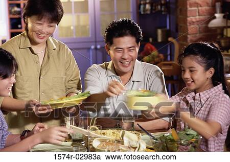 Parents with their children at a dining table View Large Photo Image Stock Image - Parents with their children at a dining table. Fotosearch