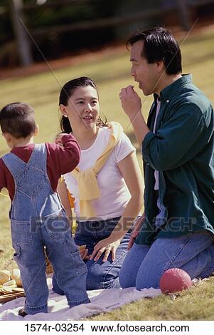 Parents with their son at a picnic View Large Photo Image Picture - Parents with their son at a picnic. Fotosearch
