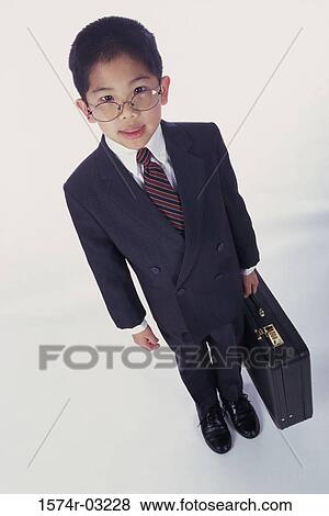 Portrait of a boy dressed as a businessman holding a briefcase View Large Photo Image Stock Photo - Portrait of a boy dressed as a businessman holding a briefcase. Fotosearch