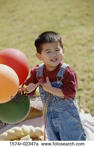 Portrait of a boy holding balloons View Large Photo Image Stock Image - Portrait of a boy holding balloons. Fotosearch