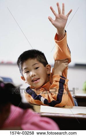 Portrait of a boy with his arm raised in class View Large Photo Image Stock Photo - Portrait of a boy with his arm raised in class. Fotosearch