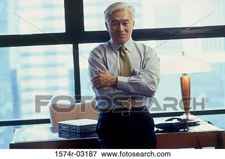 Portrait of a businessman standing with his arms folded View Large Photo Image Stock Photo - Portrait of a businessman standing with his arms folded. Fotosearch