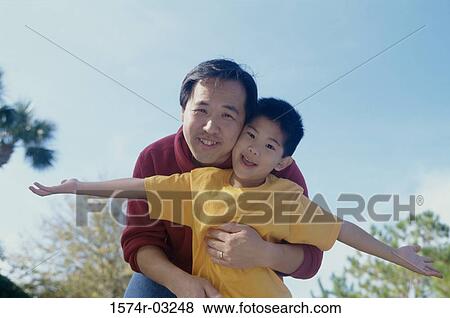Stock Photo - Portrait of a father hugging his son. Fotosearch