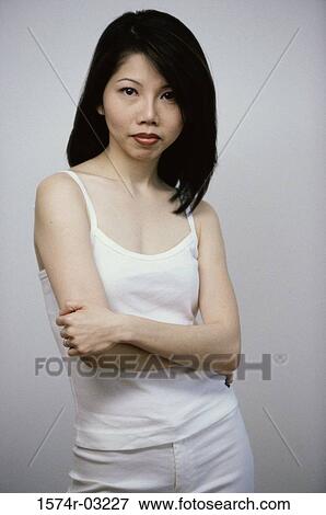 Stock Photo - Portrait of a mid adult woman standing with her arms folded. Fotosearch