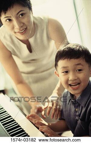 Portrait of a mother teaching her son the piano View Large Photo Image Stock Image - Portrait of a mother teaching her son the piano. Fotosearch