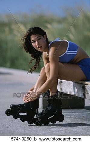 Stock Image - Portrait of a young woman adjusting her inline skates. Fotosearch