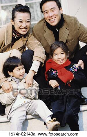 Stock Image - Portrait of parents smiling with their son and a daughter. Fotosearch
