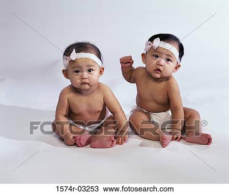 Portrait of two baby girls wearing diapers and bows on their heads View Large Photo Image Stock Image - Portrait of two baby girls wearing diapers and bows on their heads. Fotosearch