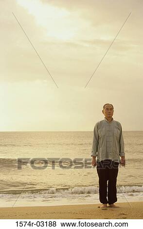 Senior man standing on the beach View Large Photo Image Stock Photo - Senior man standing on the beach. Fotosearch