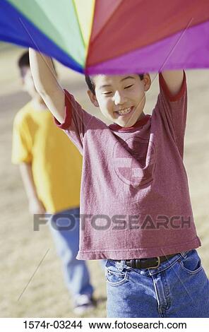 Two boys flying a kite View Large Photo Image Picture - Two boys flying a kite. Fotosearch