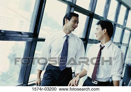 Two businessmen talking in an office View Large Photo Image Stock Image - Two businessmen talking in an office. Fotosearch