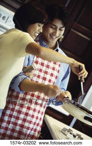 Young couple cooking in the kitchen View Large Photo Image Stock Image - Young couple cooking in the kitchen. Fotosearch