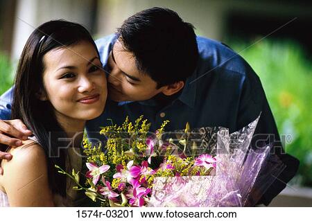 Young man whispering into a young woman's ear View Large Photo Image Stock Image - Young man whispering into a young woman's ear. Fotosearch