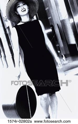 Stock Image - Young woman carrying a bag. Fotosearch