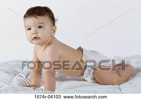 Stock Image - Baby boy crawling on a bed. Fotosearch