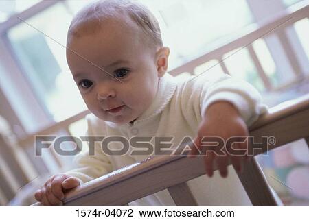 Close-up of a baby boy holding the railing of a crib View Large Photo Image Stock Image - Close-up of a baby boy holding the railing of a crib. Fotosearch