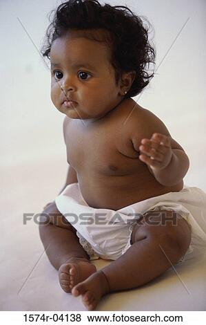Stock Photo - Close-up of a baby girl sitting. Fotosearch