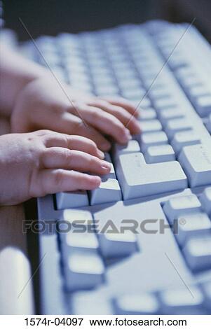 Stock Photo - Close-up of a baby's hands on a computer keyboard. Fotosearch