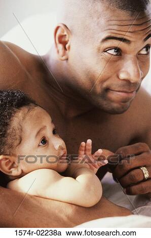 Stock Image - Close-up of a father holding his baby boy. Fotosearch